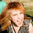 A static pixelated image of a person with long reddish-brown hair, closed eyes, and a neutral expression, wearing a dark jacket over a light shirt.