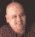 Pixelated image of a person with a bald head and brown clothing, showing animation changes including a white face effect and orange star outline.
