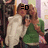 Two figures in a pixelated image: one in white dress, another in green top with brown hair and black text above head.