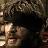 Pixelated static image of a person with dark hair and light skin, partially obscured by low resolution and compression artifacts.