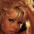 Pixelated close-up of a person's face with brown hair and warm lighting, appearing to be in motion or interacting with an object near the mouth.