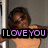 Pixelated image of a person with dark curly hair wearing an orange top, overlaid with purple text reading "I LOVE YOU" on a black banner.