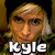 Pixelated image of a person with light brown hair and a dark cap, wearing a green patterned shirt, with overlaid text reading 'Kyle Burns' and 'FTSK' in white block letters.