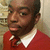A person in a red sweater with white collar and dark tie, shown across four with subtle head position changes