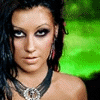 A person with dark hair and heavy eye makeup wears a black choker with a silver circular pendant against changing background colors.