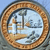 Circular icon with brown textured border enclosing a light blue background featuring abstract dark gray and brown shapes.