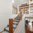 Pixelated image of a wooden staircase with metal railings, viewed from below against a light background.