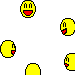 Yellow cartoon character with blue eyes, green spots, and a wide open mouth showing two teeth against gray background.