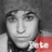 Pixelated grayscale portrait of a person with dark hair, wearing a red garment with white text on the right side.