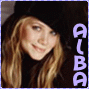 A person with long light brown hair and a black hat smiles, standing against a dark background with vertical purple text reading "ALBA" on the right.
