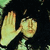 A pixelated image shows a light-colored hand with fingers extended against a dark background, with faint green elements on the left edge.
