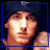 Two side-by-side pixelated frames of a person wearing a dark beanie and sleeveless top against a black background, with blue and white borders respectively.