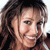 Pixelated close-up of a person with long brown hair and light skin tone against a white background, rendered in low-resolution 256x256 pixels.