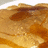 Pixelated image of a golden-brown pancake with syrup on the left, and cyan text reading "i smell a big pandcake !!!!" on black background.