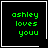 Green pixelated text 'ashley loves youu' on black background with white border, featuring a white heart symbol in top-right corner and white star symbol in bottom-right corner.