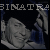 Pixelated static image featuring a partial face with visible hair and clothing, overlaid text reading "BINATR", dark background, and blue accents on the right side.