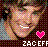 Pixelated static buddy icon featuring a cartoon-style face with closed eyes, pink heart symbol, and partial text at the bottom against dark background.