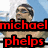 A four- shows a swimmer with arms raised, wearing goggles and a cap, against a blue background. Text overlays read "michael phelps" in red, "is" in white, and "hot!" in blue