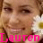 Pixelated close-up of a person's face with brown hair, holding a white and yellow flower near the right cheek, pink text reading 'Lauren' at bottom.