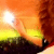 A static pixelated image depicts a bright sun over a yellow-green field with dark brown terrain beneath, set against an orange sky.