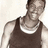 Pixelated image of a person wearing a dark tank top with a white undershirt visible underneath, standing against a light background.
