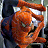 A pixelated Spider-Man figure in orange and red tones with a dark background, next to green text reading 'OriginalIcons.com' on a solid green backdrop.