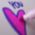 A pink heart-shaped icon with a blue outline and winged emblem above, featuring the word 'love' in pixelated text at bottom right.