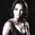 Pixelated grayscale image of a person with shoulder-length hair wearing a sleeveless top against a dark background.