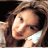 Static 48x48 pixel icon of a woman's face with brown hair, blue eyes, and red lips in profile view against dark background.
