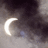 A crescent moon icon with a bright white glow against a dark, cloudy night sky background.