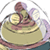 Pixelated static image of a character with brown hair and purple accents riding a large yellow circular object, possibly a vehicle or platform, against a white background.