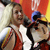 Pixelated static image of two women in sports attire with a blurred background featuring red, yellow, and blue tones.