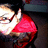Pixelated image of two figures in close proximity, one wearing red clothing and the other in light tones, against a dark background.