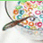 A 4-frame animated contact sheet showing a bowl of colorful cereal with a spoon, paired with pink pixelated text phrases about being a cheerio or fruit loop.