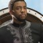 Pixelated static image of a person in dark clothing with light-colored shoulder accents against a bright background.