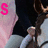 A static image shows a person in dark clothing with light-colored sleeves holding an object, overlaid by pink text that changes from 'S' to 'K' to 'SK'.
