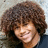 A pixelated image shows a person with curly brown hair on the left, next to a blue background with black text reading "i lov him" on the right.