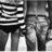 Black-and-white pixelated image showing a stylized figure with striped clothing and vertical lines below, set against a gradient background.