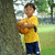 A child in a yellow shirt and dark blue shorts stands beside a tree holding an orange object, with background variations across frames.