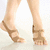 A pixelated close-up of a person's lower legs and feet wearing brown strappy sandals on a light reflective surface.