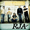 Group of people standing in front of a wall with 'RJA' text below, showing subtle animation changes in the lower-right corner.