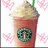 Pixelated image of a pink drink with whipped cream and green straw, surrounded by pink hearts on white background, next to bright pink with 'yummilious' text