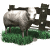 Animated sequence of a sheep standing beside a wooden fence on green grass, showing subtle head movement from left to right across frames.
