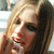 Pixelated close-up of a person with light brown hair, showing partial facial features including eyes, nose, and mouth against a blurred background.