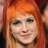 A person with long orange hair and light skin appears in a of four , each showing slight variations in facial expression and head position