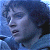 Pixelated close-up of a person's face with closed eyes, dark curly hair, and a blue-toned background.