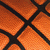 A static close-up of a basketball's textured surface with orange and black seams, showing no motion or additional elements