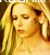 Pixelated close-up of a person with long blonde hair, closed eyes, and warm-toned skin under soft lighting.