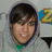 Pixelated static image of a person with dark hair and light skin wearing a green-collared shirt, partially visible yellow number '2' on the right.