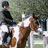 A pixelated image shows a person riding a brown and white horse jumping over a white fence, with text reading "Abby & Tazz" on the right side.